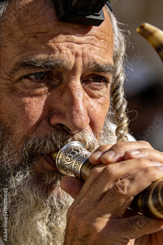 Wallpaper Mural Close-up portrait of an elderly man with a long white beard and sideburns blowing a shofar with a shallow depth of field in a warm and spiritual mood. Torontodigital.ca