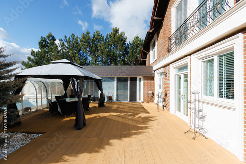 Sunny porch review. Modern deck with tools and planters in daylight