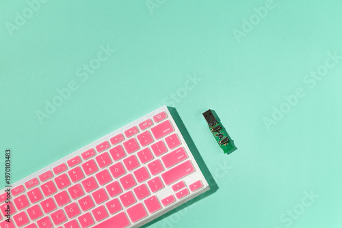 USB board and pink keyboard on mint turquoise background, pastel colors, copy space, minimalist design concept