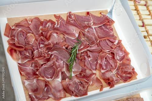 Cured Italian Prosciutto Ham with Rosemary Garnish in Catering Box