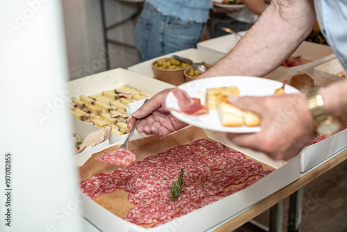 Man Serving Himself at a Gourmet Tapas Buffet during a Social Event