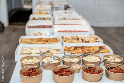 Gourmet Tapas Buffet with Assorted Meat, Cheese, and Bread in White Catering Boxes
