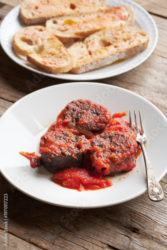 Burgos Blood Sausage Served With Tomato Sauce and Bread on a Rustic Table