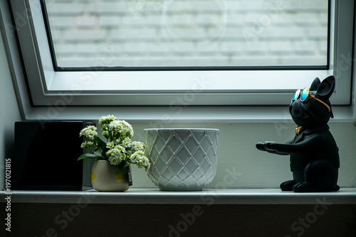 Stylish black dog figurine wearing round mirrored sunglasses