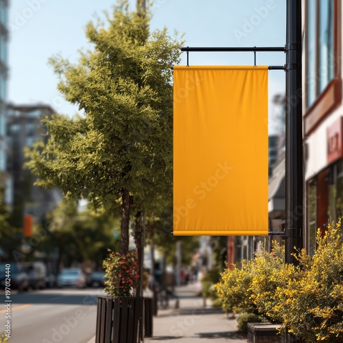 Vibrant Yellow Banner on Urban Street with Greenery and Buildings