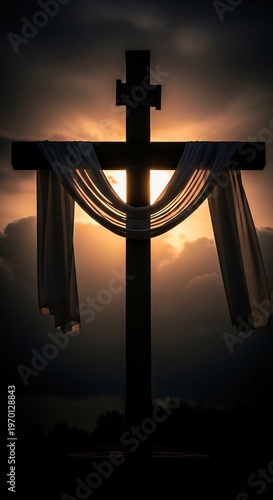 Dramatic Silhouette of a Christian Cross Draped with Fabric Against a Fiery Sunset Sky.