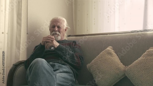 Senior man crying in emotional distress after bad news at home