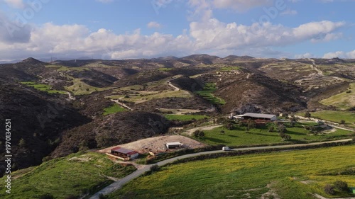 Aerial drone view of rugged hills and valleys with patches of green vegetation in the Cyprus