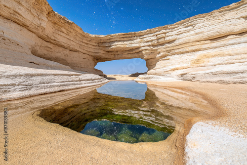 Natural rock arch desert cave crystal pool star reflection sandstone cliff blue sky shallow water landscape view