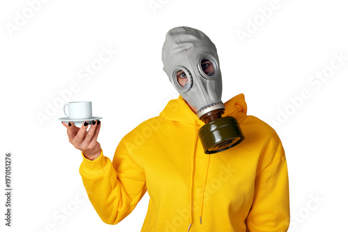 Individual in yellow hoodie wearing gas mask, holding white coffee cup and saucer isolated on transparent background.