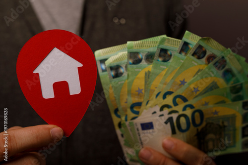 Hand holding house icon and...