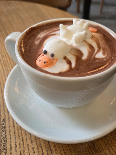 Hot cocoa with marshmallow duck in cup on wooden table