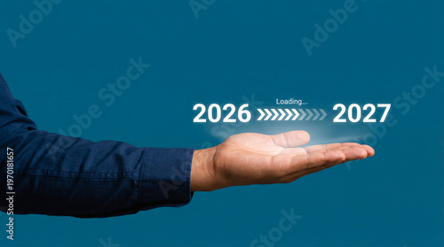 Progress and transition from 2026 to 2027 year concept. A person pointing to loading bar transitioning from 2026 to 2027, progress, future planning, and new year goals. 