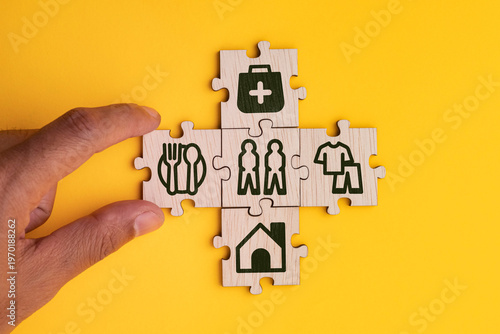 Foto wooden cube with icons of food, Clothing, housing, medical bag, four basic human needs concepts