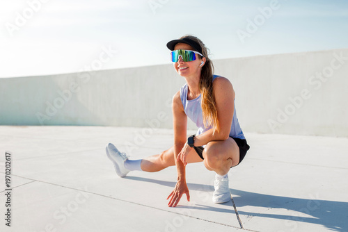 Bild auf Leinwand Smiling athlete stretches on a sunny rooftop, ready for an energetic workout ses