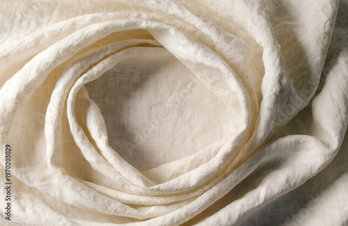 Natural linen fabric swirl texture creating concentric circles for organic textile background in warm neutral cream tone.