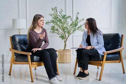 Photography Young woman patient in therapy session talking with female psychotherapist