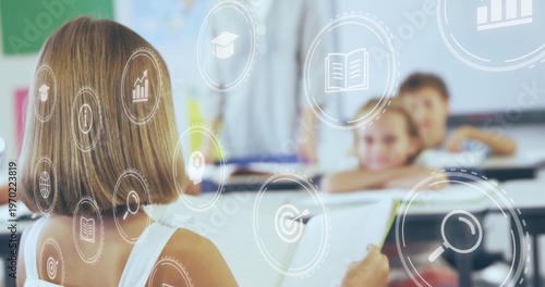 Holding tablet child with bob in white tank top studying in classroom, overlay icons, copy space