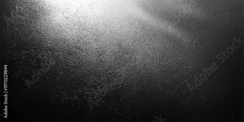 Abstract textured black background with gradient lighting, highlighting the intricate texture, creates a visually captivating surface.