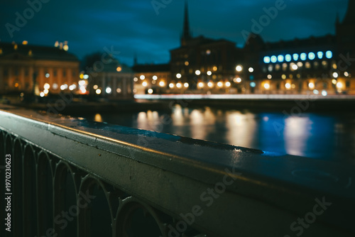 Focused view on a bridge railing with city bokeh