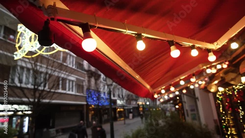 Festive String Bulb Lights Glowing Over A Cozy Cafe Terrace In Winter Create A New Year Atmosphere