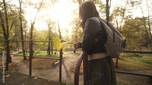 Stylish Woman Holds Yellow Maple Leaves While Enjoying The Golden Autumn Park Atmosphere