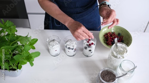 Woman Preparing A Healthy Breakfast For Kids With Yogurt, Chia Seeds, And Fresh Berries, Top View