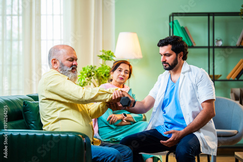 Indian physiotherapist helping a senior man with dumbbell exercises for forearm strength.