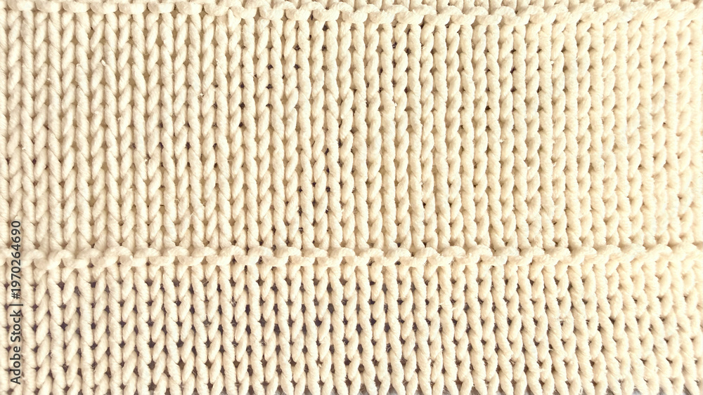 Fototapeta premium soft cream ribbed knit fabric closeup with intricate yarn texture and horizontal pattern band detail
