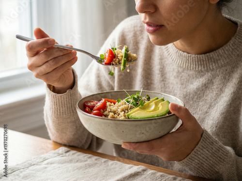 Woman Enjoying Healthy Grain Bowl with Avocado and Quinoa in Natural Light