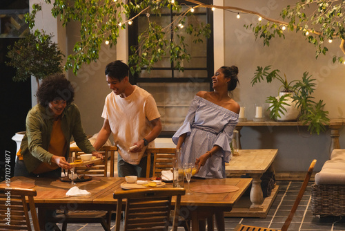 Two women and one man arranging table, preparing dinner with animated menu guiding plate layout