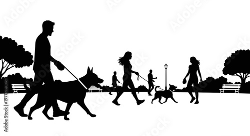 Silhouettes of people walking dogs in a park.