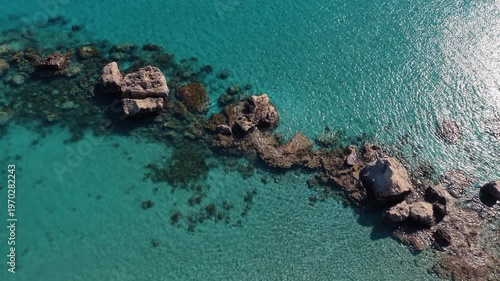 Aerial drone view of a quiet Konnos Beach rocky bay with crystal clear turquoise water in Cyprus