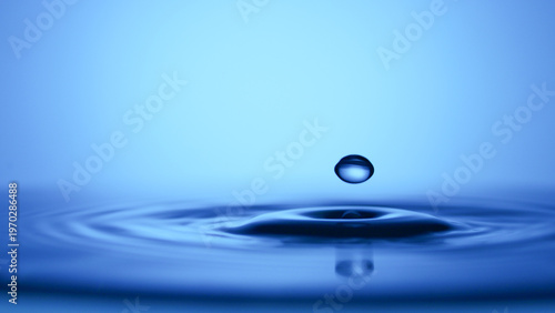 A single water drop creates ripples in the water, showcasing a moment of impact and tranquility
