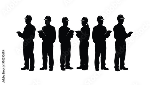 Silhouettes of construction workers or engineers holding tablets