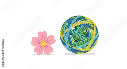 A vibrant, multi-colored ball of rubber bands is positioned next to a single pink cherry blossom flower on a white background.