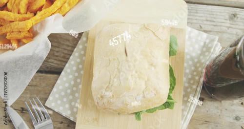 Gloved-hand placing fries by sandwich on board, numbers drifting, camera pulling back, forming meal