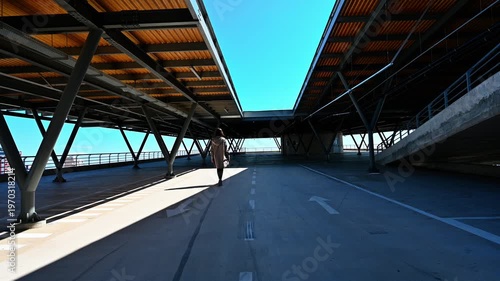 Young woman on an empty parking lot in Durres, Albania. Urban environment, freedom, lifestyle, casual walk, city scene, outdoor activity, relaxed mood.