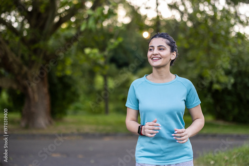 Young woman jogging outdoors, smiling, enjoying healthy exercise