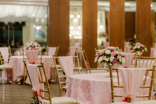 Foto Elegant Reception Hall Decor with Pink Tablecloths and Fresh Floral Arrangements