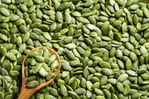 Pumpkin seeds on spoon and background