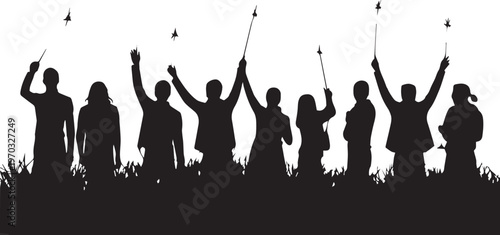 Silhouettes of people celebrating with sparklers in grass