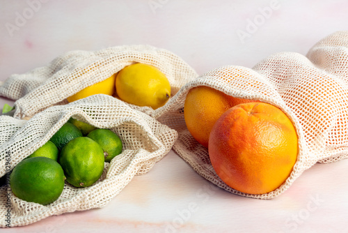 Grapefruit, lemon and limes in reusable grocery produce mesh bag