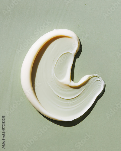 Foto Creamy white cosmetic smear texture on sage green background minimalist swatch