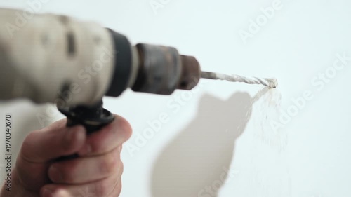 : Close up of man drilling hole in wall with electric drill for shelf installation, 10-bit 4K.