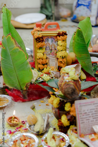 Картината върху платно Vibrant Hindu puja setup with banana leaves, flower garlands, and devotional ite