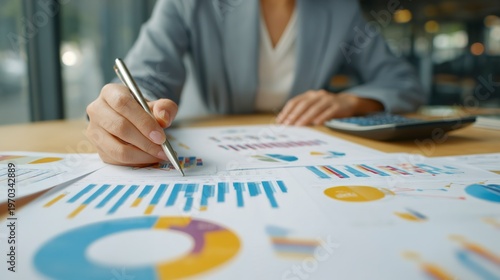 Analyzing Financials: An overhead shot captures a diligent individual meticulously reviewing charts and data. A scene that conveys diligence, precision, and the intricate world of financial analysis.