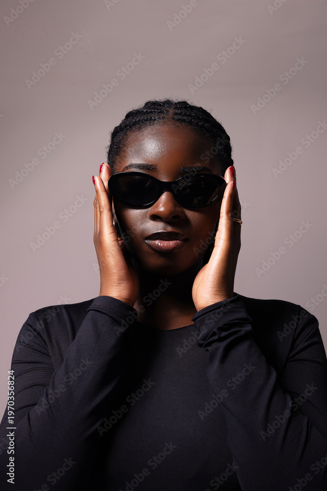 Fototapeta premium African American young woman wears sunglasses looking at the camera and posing over white background. 