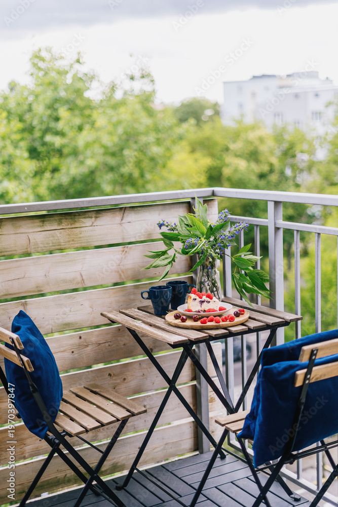Obraz premium Cozy balcony setup with breakfast and views in an apartment during summer