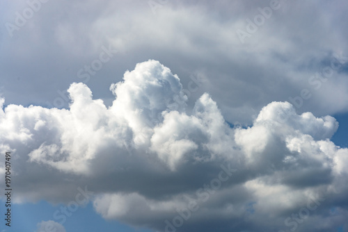 Cumulus white clouds bofies towering in clear blue sky background.